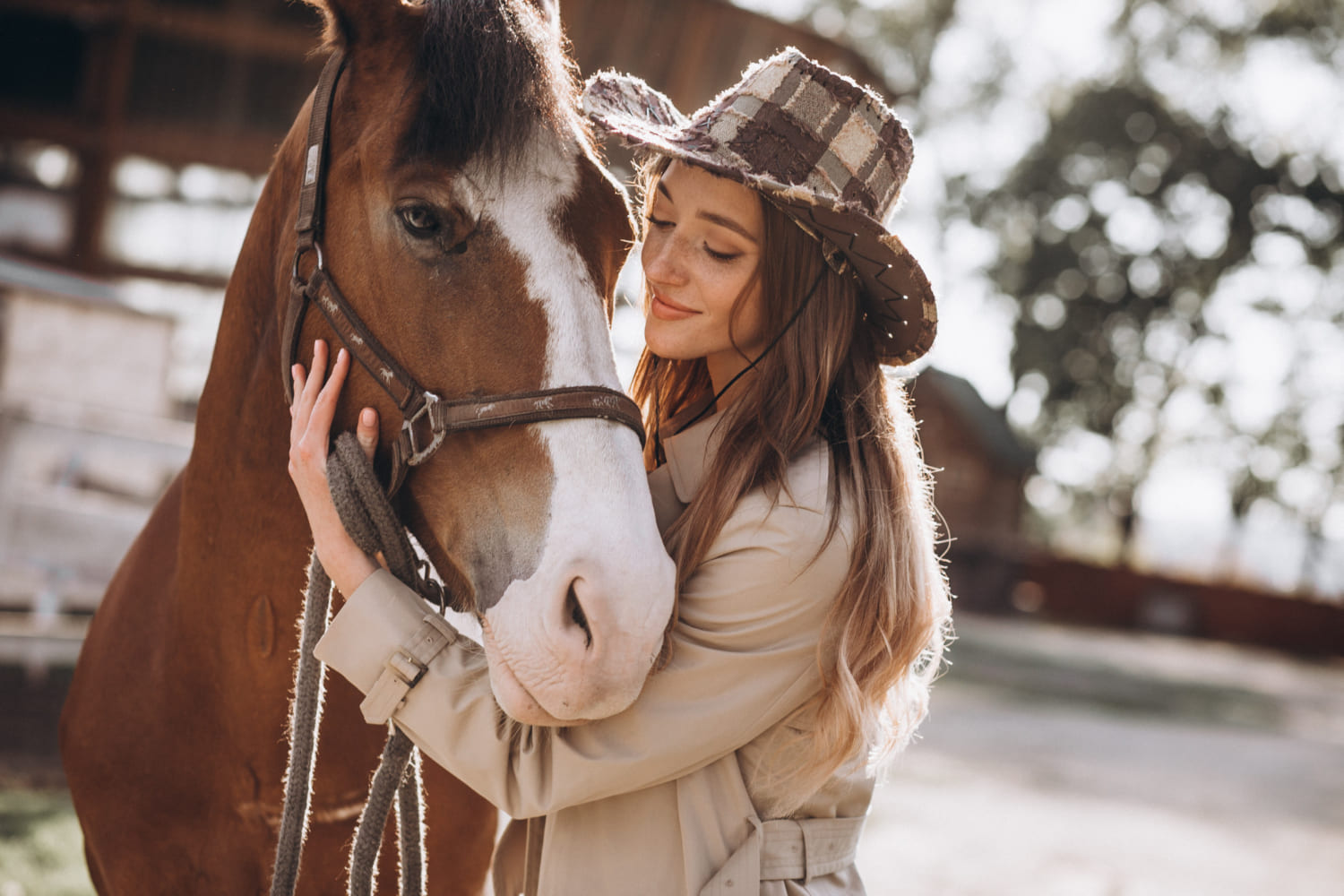 Mujer con sombrero cowboy abrazando a un caballo marrón
